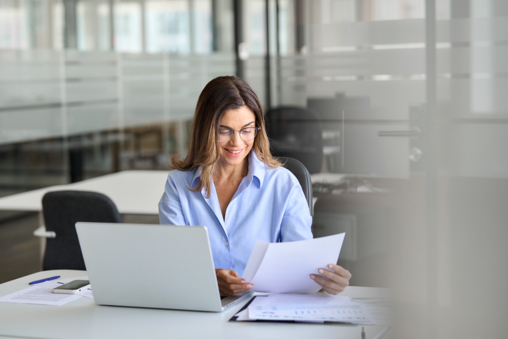 Frau begutachtet Dokument am Laptop